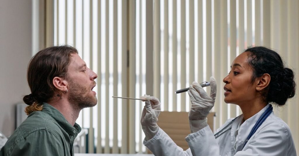Medica examina a garganta de paciente com abaixador de lingua
