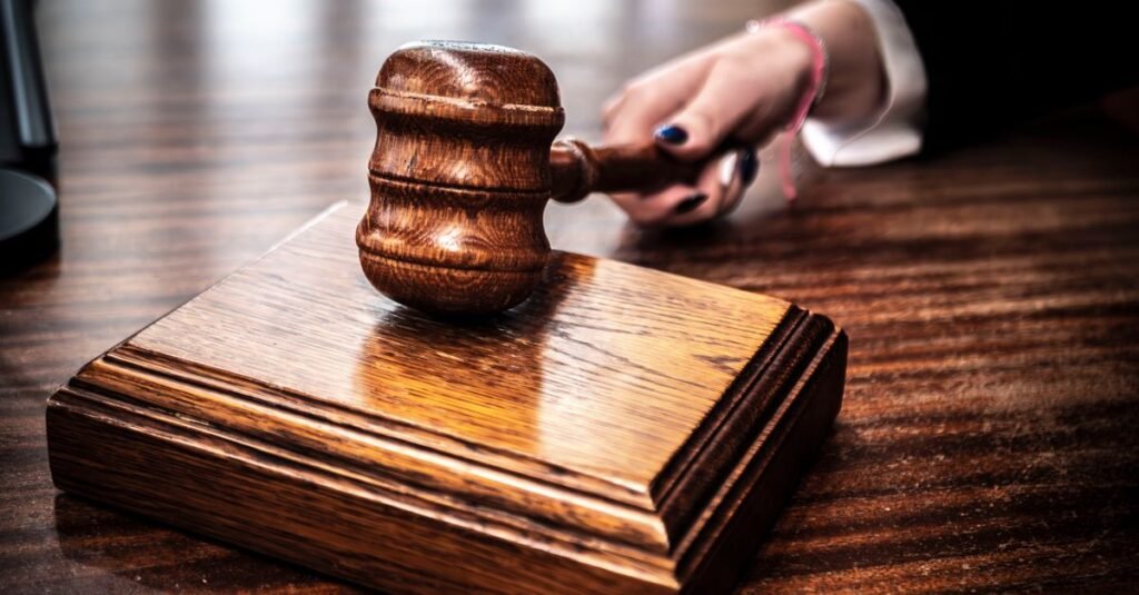 Martelo de juiz de madeira sobre base em mesa de tribunal