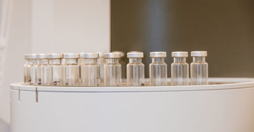 Frascos de vidro para medicamentos alinhados em equipamento de laboratório farmacêutico