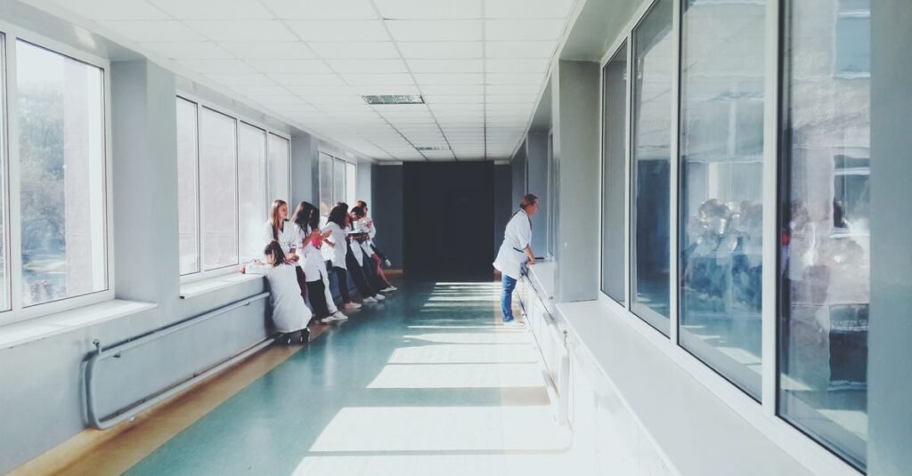 Corredor de hospital com profissionais de saúde de jaleco branco