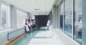 Corredor de hospital com profissionais de saúde de jaleco branco