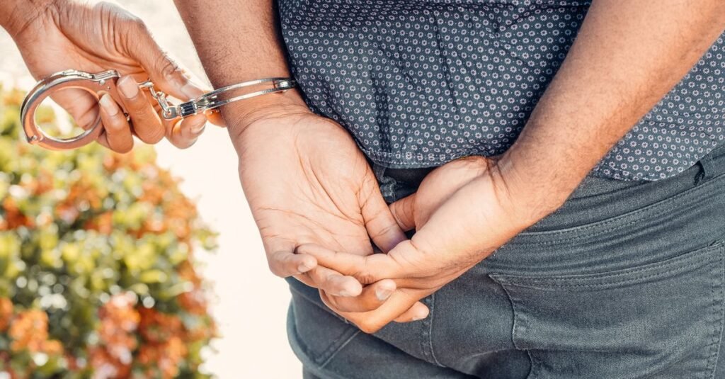 Policial algema suspeito com as mãos para trás durante abordagem