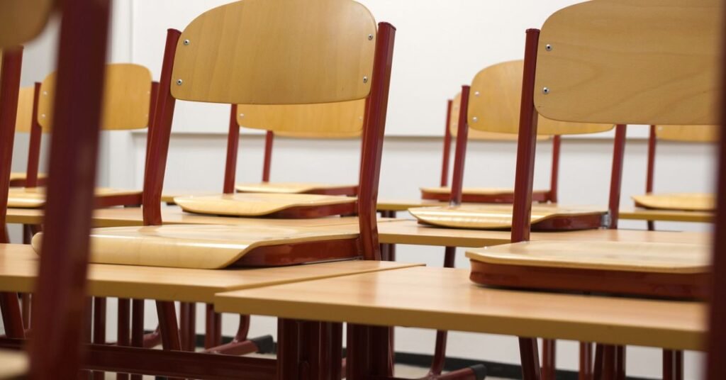 Cadeiras sobre mesas em sala de aula vazia