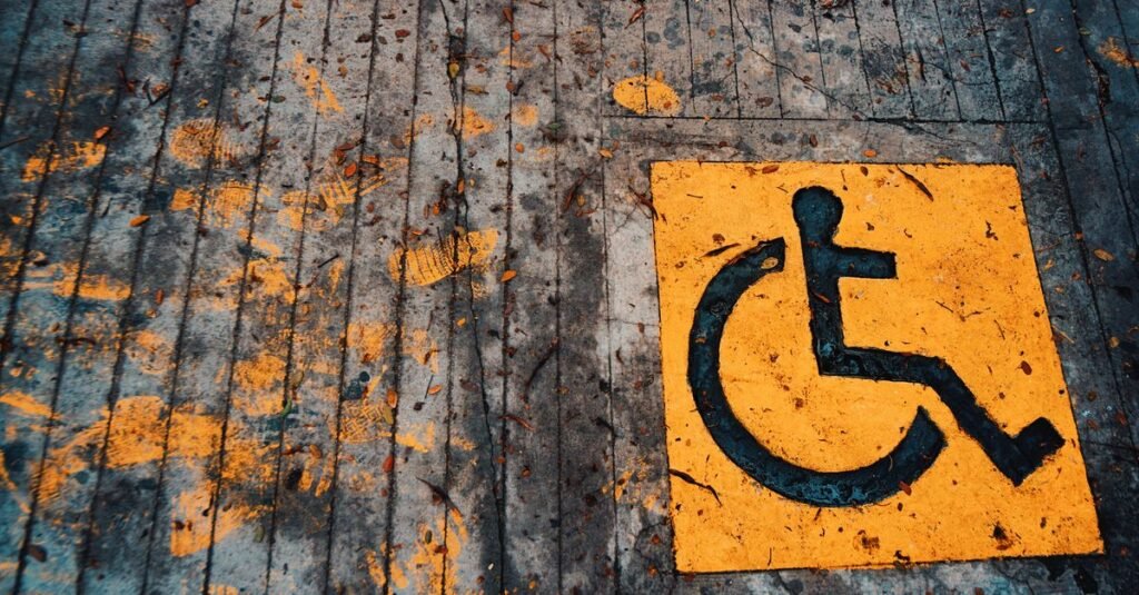 Símbolo internacional de acessibilidade pintado em amarelo no piso