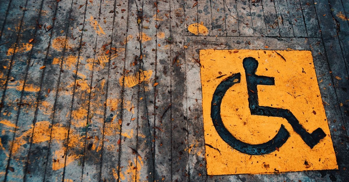 Símbolo internacional de acessibilidade pintado em amarelo no piso