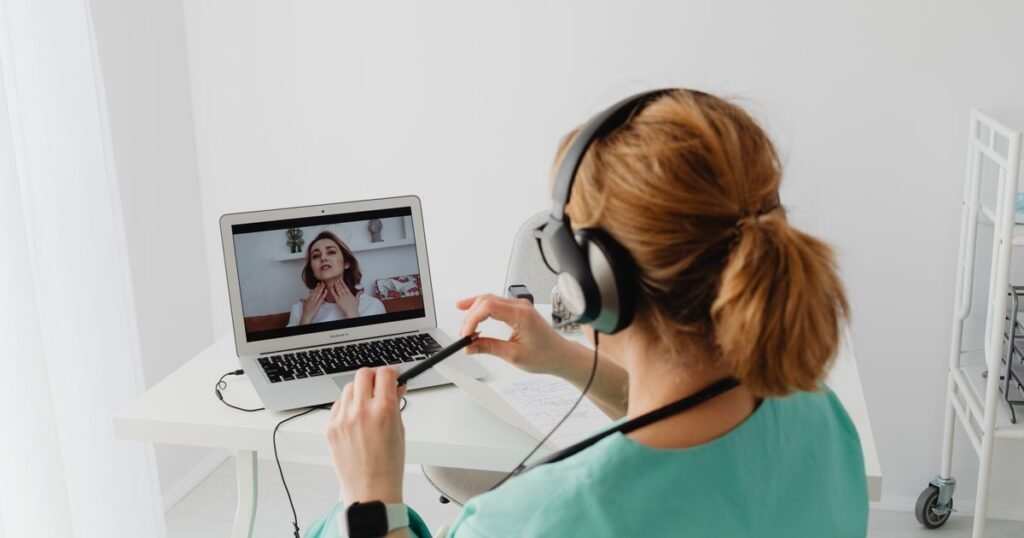 Profissional de saúde atende paciente por videochamada no computador
