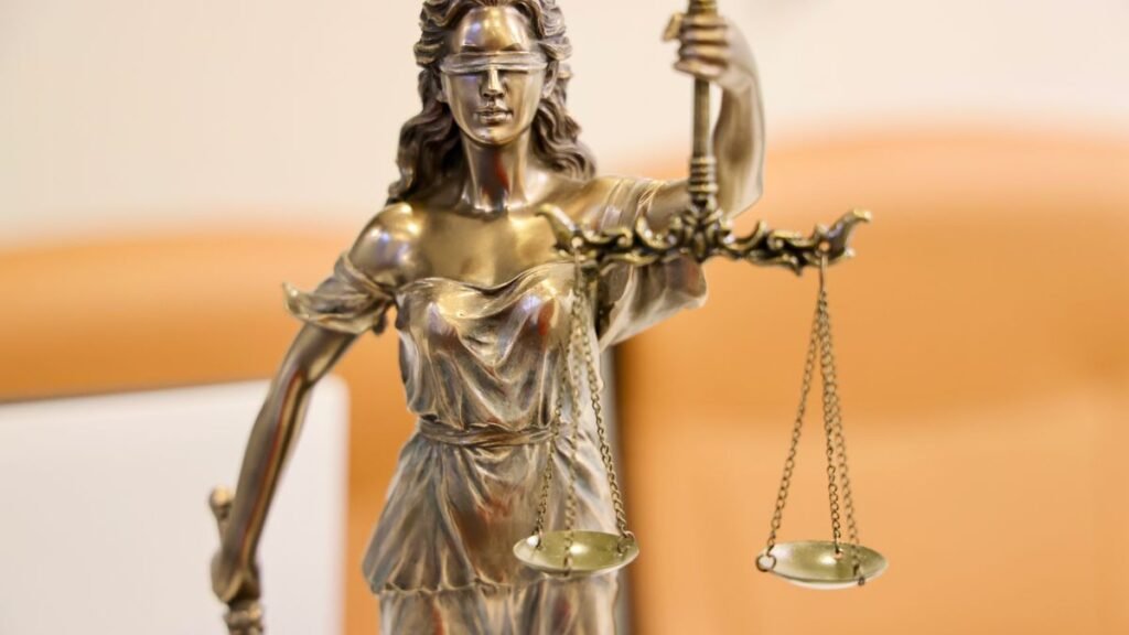 Estátua da Justiça com balança em close, símbolo do Judiciário