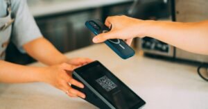 Cliente aproxima celular de maquininha para pagar com QR code