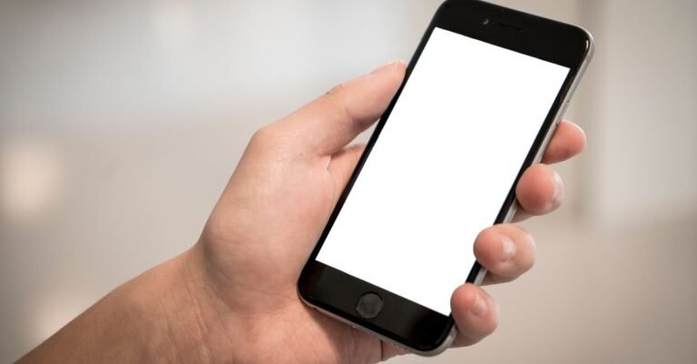 Mão segura um celular com a tela em branco, em referência ao aplicativo de alerta da vítima