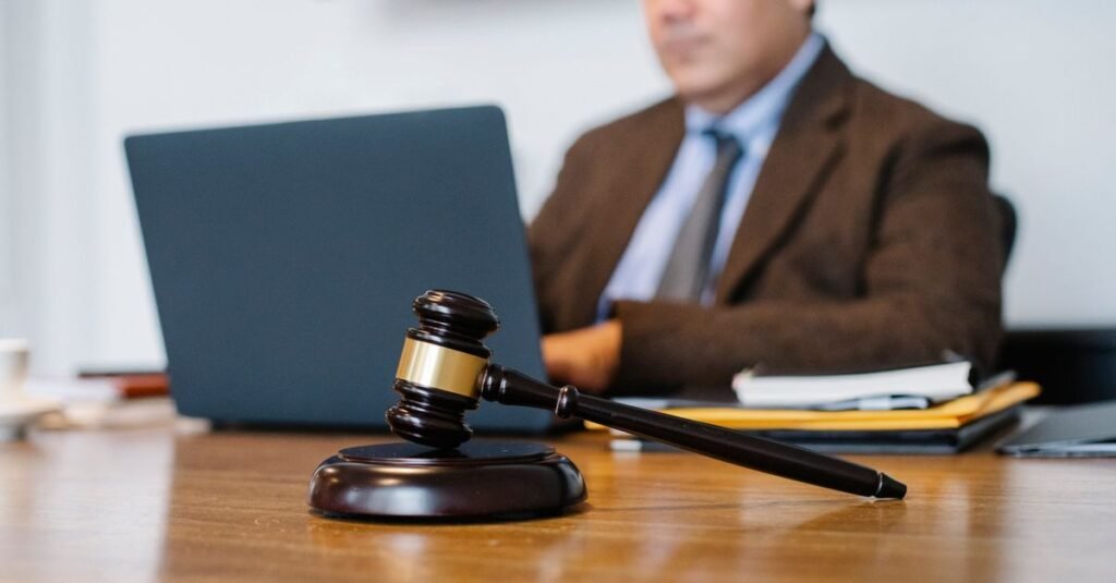 Martelo de juiz sobre mesa de madeira em ambiente de tribunal