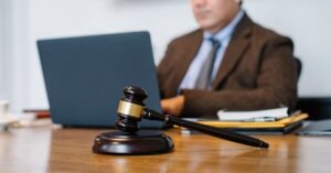Martelo de juiz sobre mesa de madeira em ambiente de tribunal
