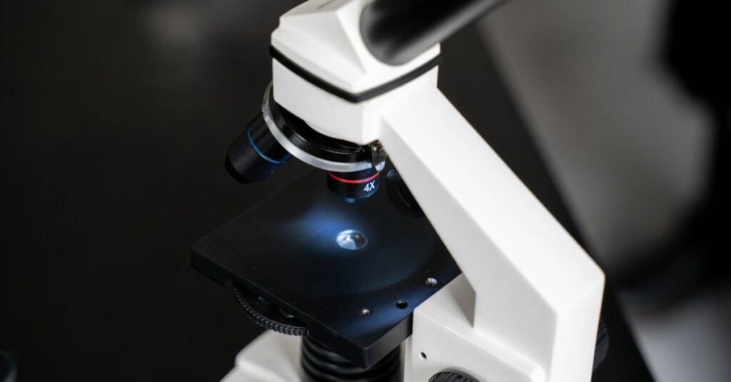 Microscópio de laboratório em close, com lâmina iluminada na base