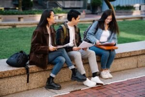 Estudantes com cadernos sentados em banco de universidade