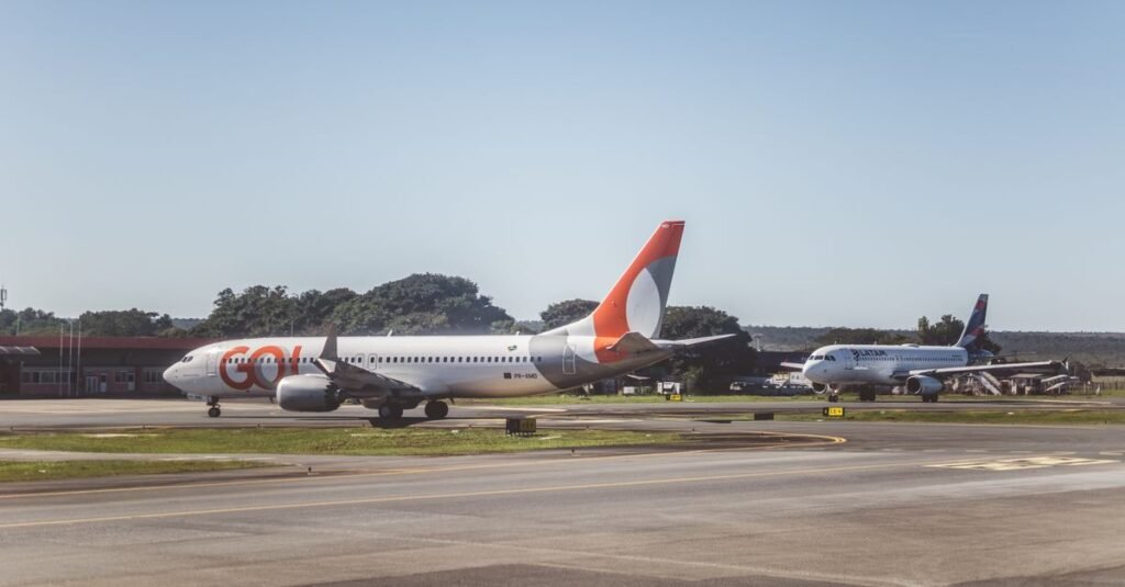Aviões da Gol e da Latam em pista de aeroporto brasileiro em dia de céu claro