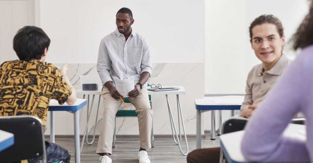 Instrutor conversa com alunos adultos em sala de aula durante curso de qualificacao profissional