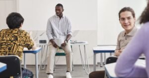 Instrutor conversa com alunos adultos em sala de aula durante curso de qualificacao profissional