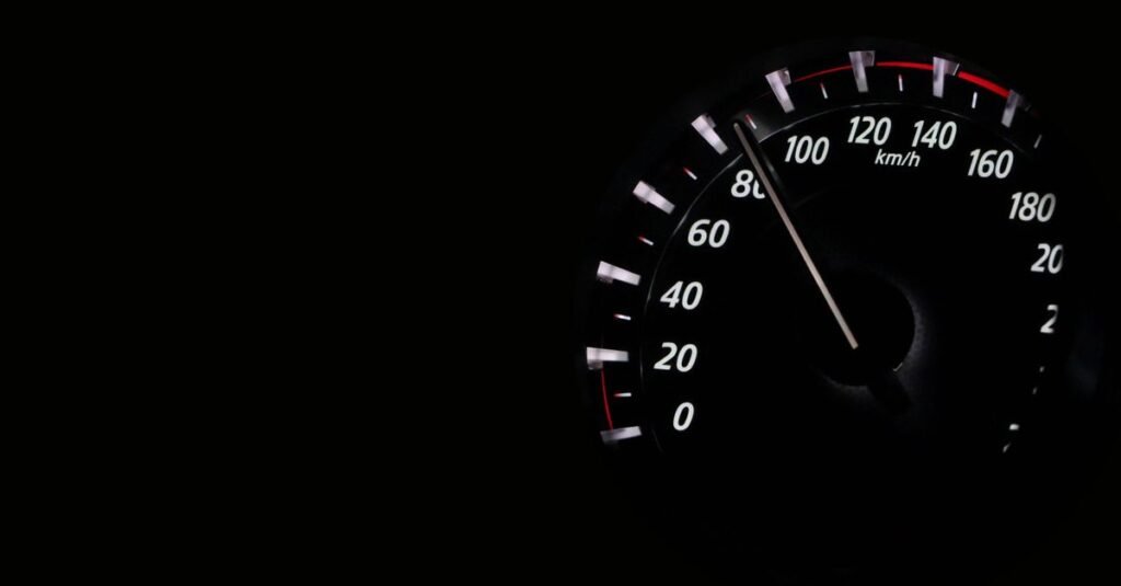 Velocímetro de carro em km/h marcando alta velocidade no escuro