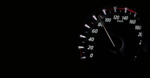 Velocímetro de carro em km/h marcando alta velocidade no escuro