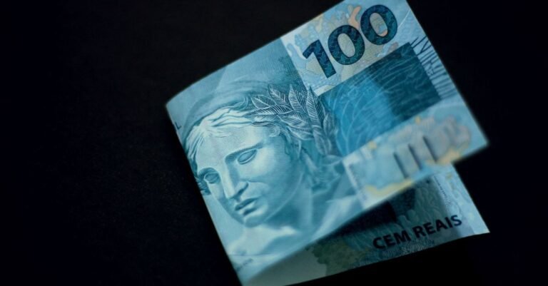 Cédula de cem reais sobre fundo preto