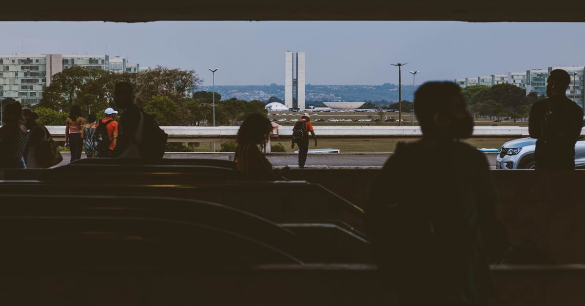 Pessoas em passagem subterranea com o Congresso Nacional ao fundo em Brasilia