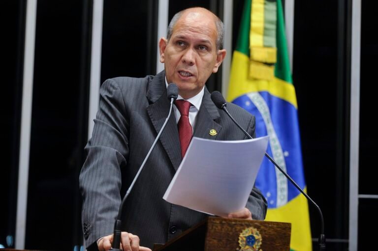 Parlamentar discursa na tribuna do plenário do Senado Federal, em Brasília, ao lado da bandeira do Brasil