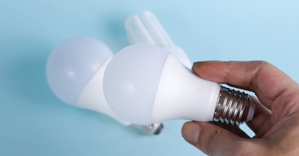 Mãos seguram lâmpadas LED, símbolo de economia de energia com a Tarifa Social