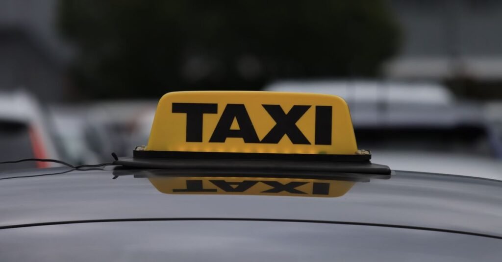 Luminoso amarelo com a palavra táxi sobre o teto de um carro