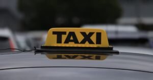 Luminoso amarelo com a palavra táxi sobre o teto de um carro