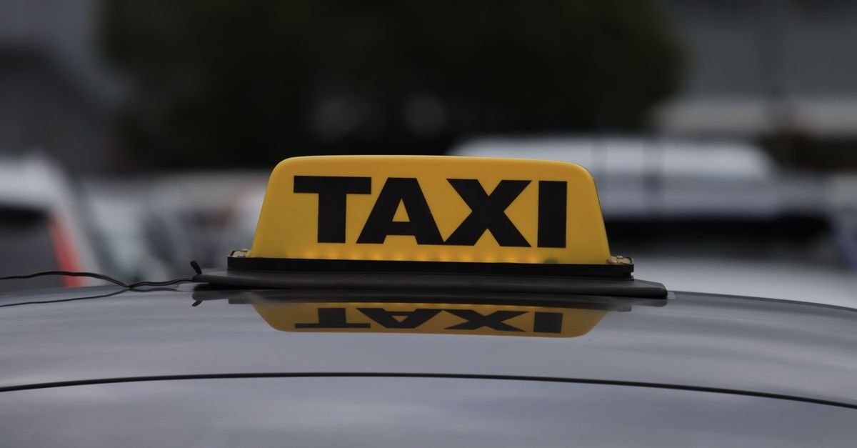 Luminoso amarelo com a palavra táxi sobre o teto de um carro