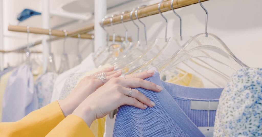 Consumidora escolhe roupas em arara de loja, em imagem que ilustra as vendas do varejo