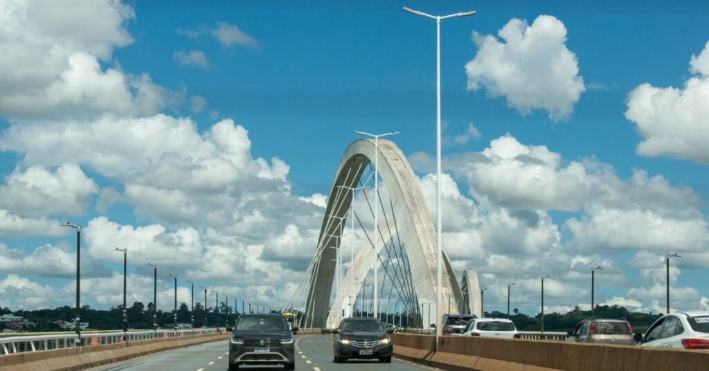 Ponte Juscelino Kubitschek vista da pista, com carros trafegando sob ceu azul em Brasilia