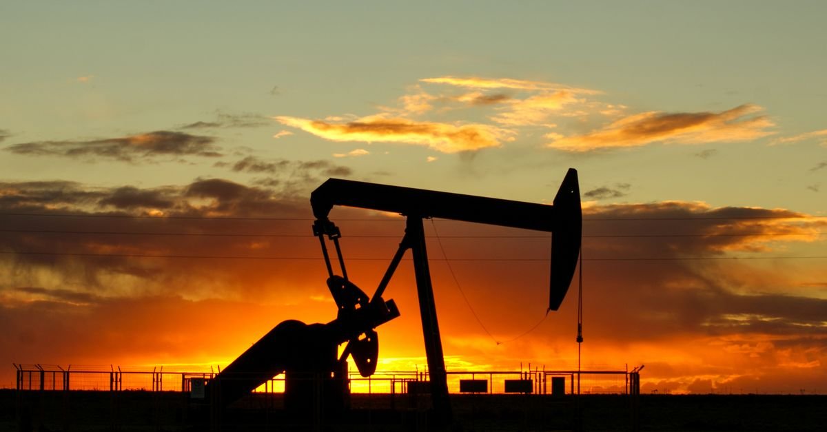Unidade de bombeio de petróleo em silhueta ao pôr do sol