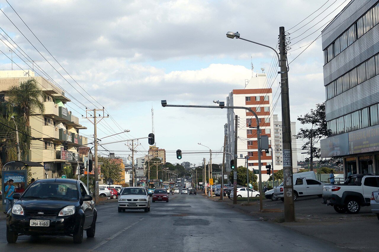 Avenida movimentada de Taguatinga, no Distrito Federal, com carros e prédios comerciais