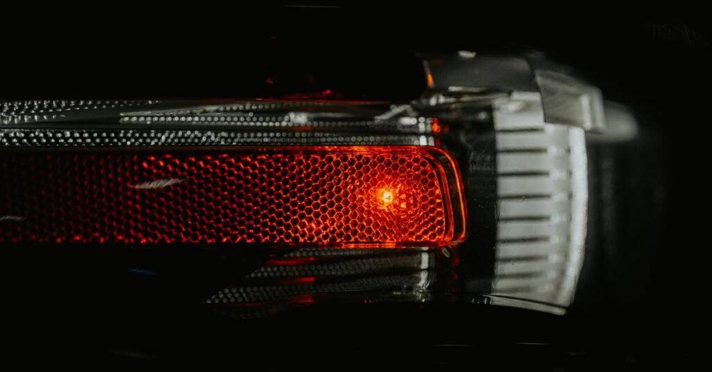 Detalhe da lanterna traseira acesa de um carro em fundo escuro