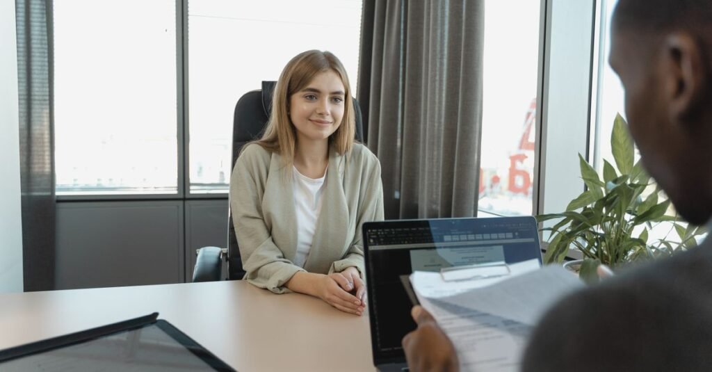 Candidata sentada diante de recrutadores durante entrevista de emprego em escritório