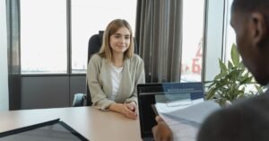 Candidata sentada diante de recrutadores durante entrevista de emprego em escritório