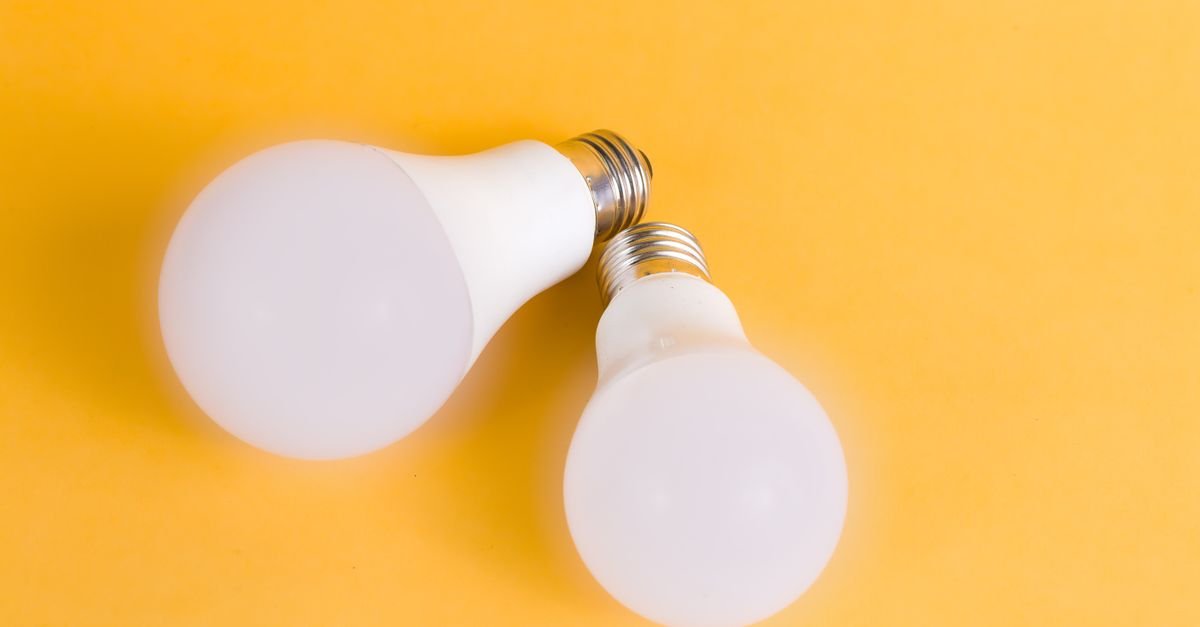 Duas lâmpadas de LED sobre fundo amarelo, representando iluminação de baixo consumo de energia