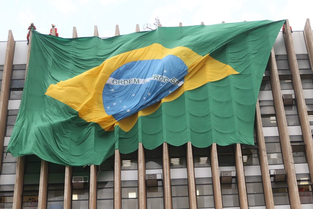 Bandeira nacional de grandes dimensões estendida na fachada do prédio anexo ao Palácio do Buriti, em Brasília