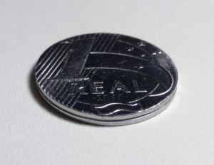 Moeda de um real em primeiro plano sobre superfície clara