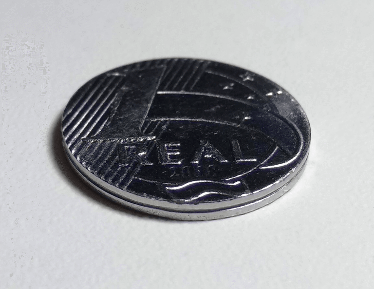 Moeda de um real em primeiro plano sobre superfície clara