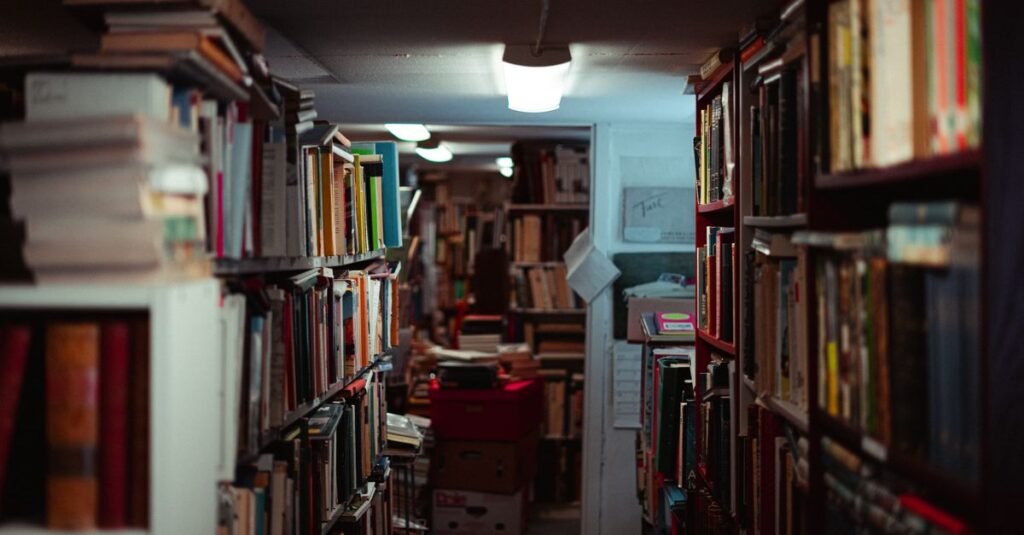 Corredor de livraria com estantes lotadas de livros dos dois lados