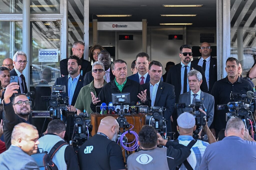 O ex-presidente Jair Bolsonaro fala a jornalistas em coletiva de imprensa ao lado do senador Flávio Bolsonaro e de outros parlamentares