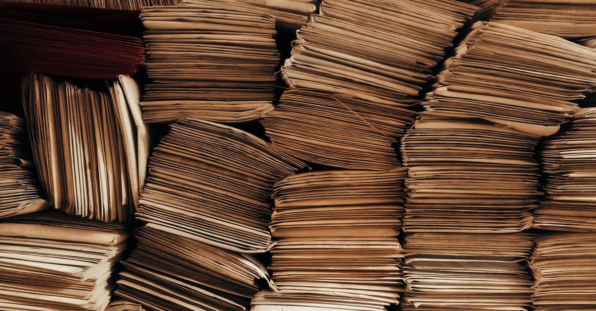 Pilhas de processos e documentos em papel arquivados