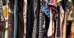 Arara com roupas variadas penduradas em cabides em um brechó