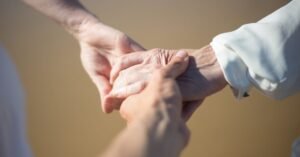 Mãos jovens segurando as mãos de uma pessoa idosa em gesto de apoio
