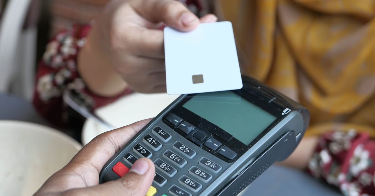 Cartão com chip aproximado de uma maquininha de pagamento
