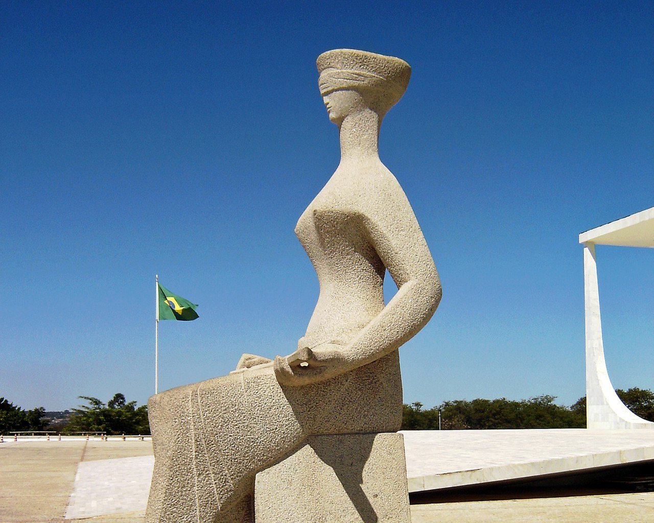 Escultura A Justiça, de Alfredo Ceschiatti, em Brasília, com a bandeira do Brasil ao fundo