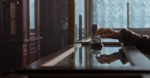 Mão toca a campainha sobre o balcão de recepção de um hotel