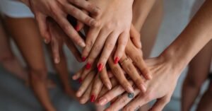 Mãos de mulheres unidas em gesto de apoio mútuo