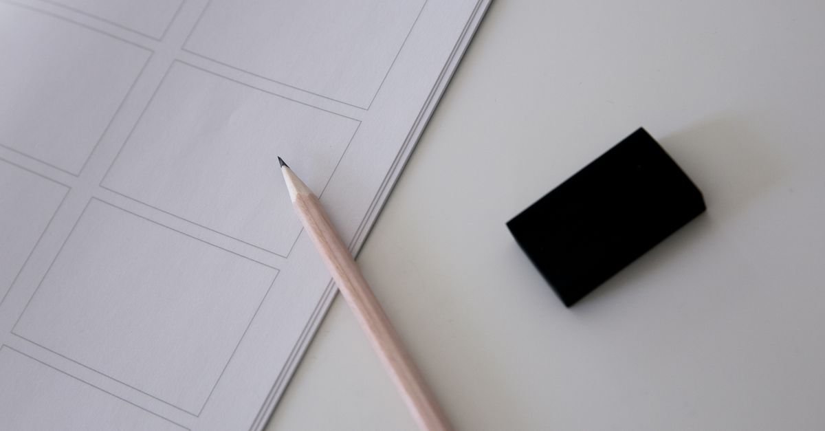 Lapis, borracha e folha de prova em branco sobre mesa clara